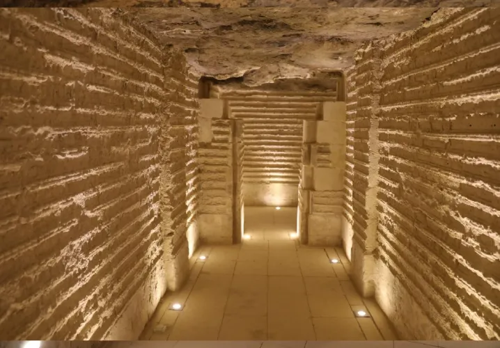 Couloir éclairé avec parois gravées à l'intérieur de la pyramide de Saqqarah.
