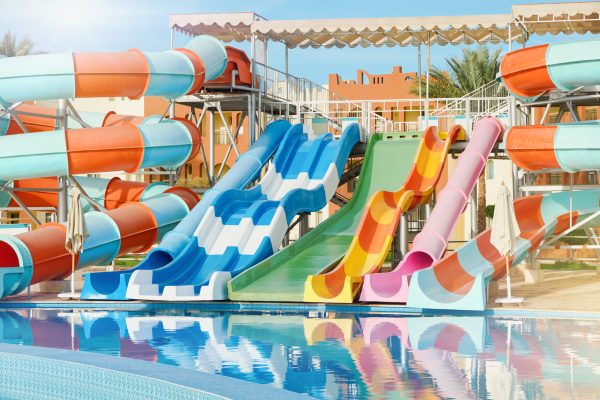 Water park with water colored flights, slides, splashes and pools at luxury hotel. summer vacation activity on holiday at outdoor waterpark or aquapark. Concept summer travel and vacation background.
